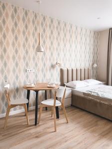 a bedroom with a bed and a table and chairs at апартаменты Pavlov у Верхнего пруда с удаленным заселением in Kaliningrad