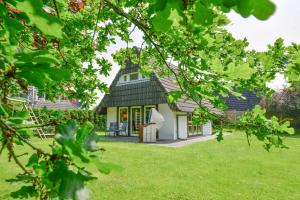 una pequeña casa con un techo negro en un patio en Landhaus Braband Ferienhaus ohne WLAN - Christian-Brütt-Weg, en Cuxhaven
