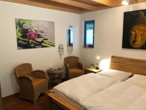 a bedroom with a bed and two chairs in it at Bio-Ferienhaus-Eifel in Rott