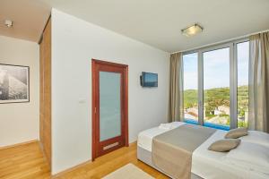 a bedroom with two beds and a large window at Villa San Mauro in Momjan +33 photos
