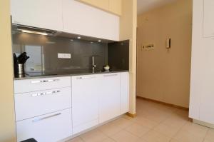 eine Küche mit weißen Schränken und einer Arbeitsplatte in der Unterkunft San Enrique B 2-2 in L'Escala