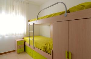 ein Schlafzimmer mit einem Etagenbett mit gelber Bettwäsche in der Unterkunft San Enrique B 2-2 in L'Escala