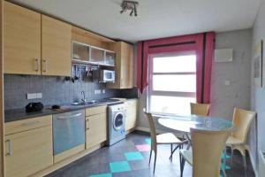 a kitchen with a table and a dining room at Comfortable, self contained 2 double beds town apartment near Pittodrie Stadium in Aberdeen