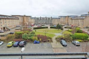 a parking lot with cars parked in front of buildings at Comfortable, self contained 2 double beds town apartment near Pittodrie Stadium in Aberdeen