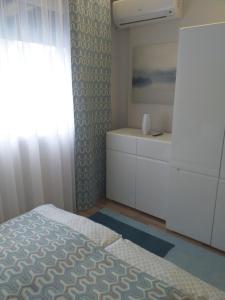 a bedroom with a bed and a dresser and a window at Elizabeth Apartman 2 in Hévíz