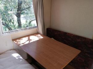 una mesa de madera en una habitación pequeña con ventana en Li Sourso, en Aups