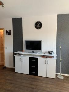 un escritorio blanco con TV en la pared en Ferienwohnung_25, en Uphusum
