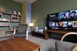 sala de estar con TV de pantalla plana grande en JAZZAPPART appartement classé 3 étoiles en Gentilly