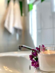 a candle and flowers sitting on a bathroom sink at Villa Ginestra in La Maddalena