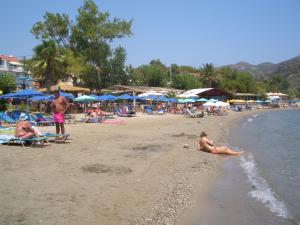 a group of people on a beach with umbrellas at Hercules Sea Front Studios in Katelios