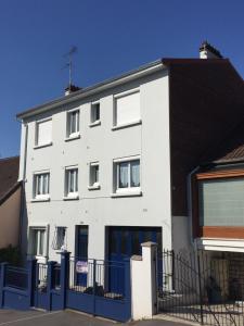 ein weißes Gebäude mit einem blauen Zaun in der Unterkunft JAZZAPPART appartement classé 3 étoiles in Gentilly