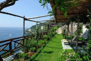 a garden with a bench and a view of the ocean at Villa Principessa Pool and Sea Access by Amalfivacation in Ravello +30 photos