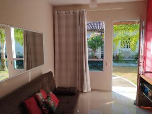 sala de estar con sofá y 2 ventanas en Casa Exclusiva a 400 Metros da Praia em Manguinhos - Condomínio com Vigilância 24hs en Serra