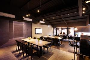 a restaurant with wooden tables and chairs and a tv at Main Inn Taipei in Taipei