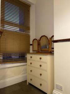 a bedroom with a white dresser and a window at Seaford Lodge Apartments in Weston-super-Mare