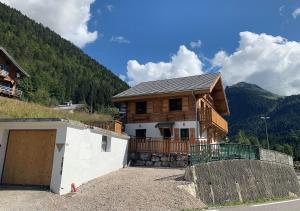 a house with a garage in front of a mountain at Just Morzine - Apartment Luna in Morzine