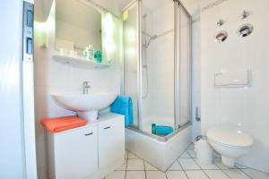 a bathroom with a sink and a shower and a toilet at Haus Miramar 31 in Ahlbeck