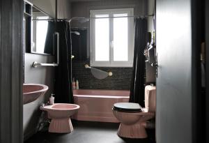ein Badezimmer mit einer rosa Toilette und einem Waschbecken in der Unterkunft JAZZAPPART appartement classé 3 étoiles in Gentilly + 50 Fotos