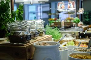 un buffet con ciotole di cibo e vasetti di erbe di Hotel Vanilla a Göteborg