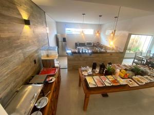 a kitchen with two tables with food on it at Hotel Pousada Paraiso Avaré in Avaré