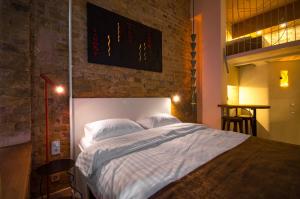 a bedroom with a large bed with a brick wall at Kyiv Whisky Box Apart-Hotel in Kyiv