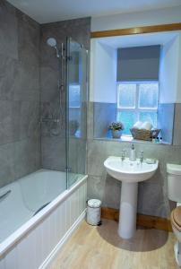 ein Badezimmer mit Badewanne, Waschbecken und Dusche in der Unterkunft Drumlanrig Mains Cottage in Thornhill + 26 Fotos