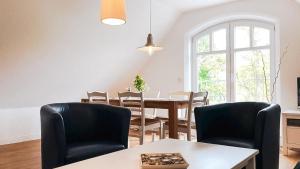 a dining room with a table and chairs and a window at Haus Alte Bäckerei - Boddenblick in Born