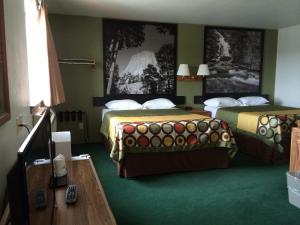 a hotel room with two beds and a table at Super 8 by Wyndham Buffalo in Buffalo