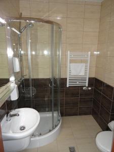a bathroom with a shower and a sink and a toilet at Hotel Wielkopolanka in Środa Wielkopolska