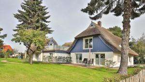 ein großes weißes Haus mit einem Strohdach in der Unterkunft Kapitänshaus - Boje in Born