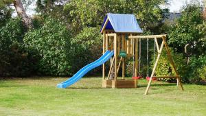 ein Spielplatz mit Rutsche und Schaukel in der Unterkunft Kapitänshaus - Boje in Born