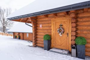 Cabaña de madera con puerta en la nieve en Osada Małysze, en Jaworzynka