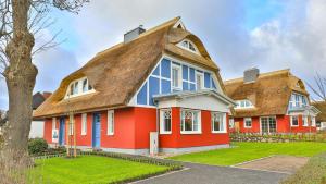 a red house with a thatched roof at Jade 3 in Born