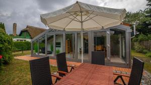 a pavilion with an umbrella on a wooden deck at Hol(t)z Hus in Born