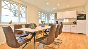 a kitchen and dining room with a wooden table and chairs at Jade 1 in Born