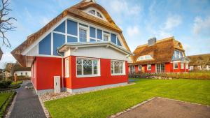 a red and white house with a roof at Jade 1 in Born