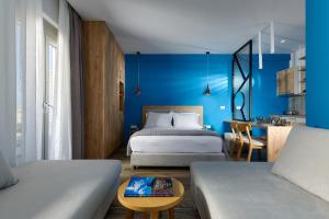 a bedroom with two beds and a blue wall at Theasea Stylish Residences in Panormos Rethymno