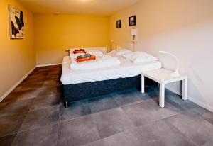 1 dormitorio con 1 cama y 1 mesa con lámpara en hureninzeeland - Marina Port Zélande comfort plus appartementen, en Ouddorp