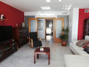 a living room with a couch and a tv and a table at Coblanca in Benidorm