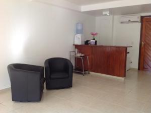 a living room with two chairs and a table at Apartamentos La Piazzetta Duplex in Pipa