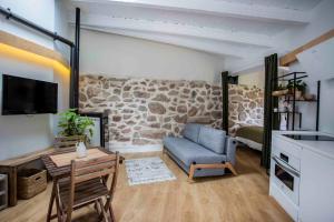 a living room with a stone wall at Finca el Veinti9 in Navacerrada