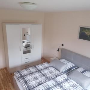 ein Schlafzimmer mit einem Bett und eine Kommode mit einem Spiegel in der Unterkunft Ferienwohnung Rösner in Herzhausen