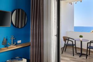 una camera con pareti blu e tavolo e sedie di Theasea Stylish Residences a Panormos