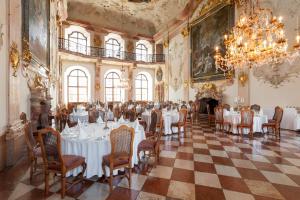 a dining room with tables and chairs and a chandelier at Hotel Schloss Leopoldskron in Salzburg