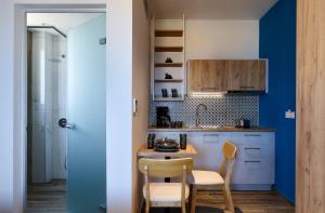 una cucina con pareti blu e tavolo e sedie di Theasea Stylish Residences a Panormos