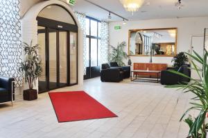 un vestíbulo con una alfombra roja en el suelo en Optima Hotel Roslagen by Reikartz en Norrtälje
