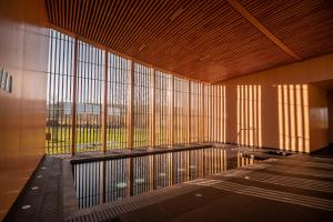 Habitación grande con ventanas grandes en un edificio en Zala Springs Health & Golf Resort, en Zalacsány