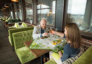 a man and a woman sitting at a table in a restaurant at Lohja Spa & Resort in Karjalohja