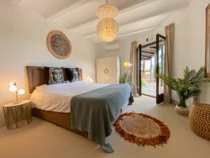 a bedroom with a large bed and a chandelier at Caballito de Mar in Moraira