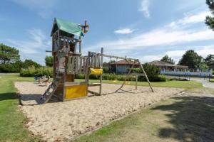a playground with a slide in the sand at Bij de duinen 300 meter van de zee gratis wifi huisdieren toegestaan thuiswerkplek in Julianadorp